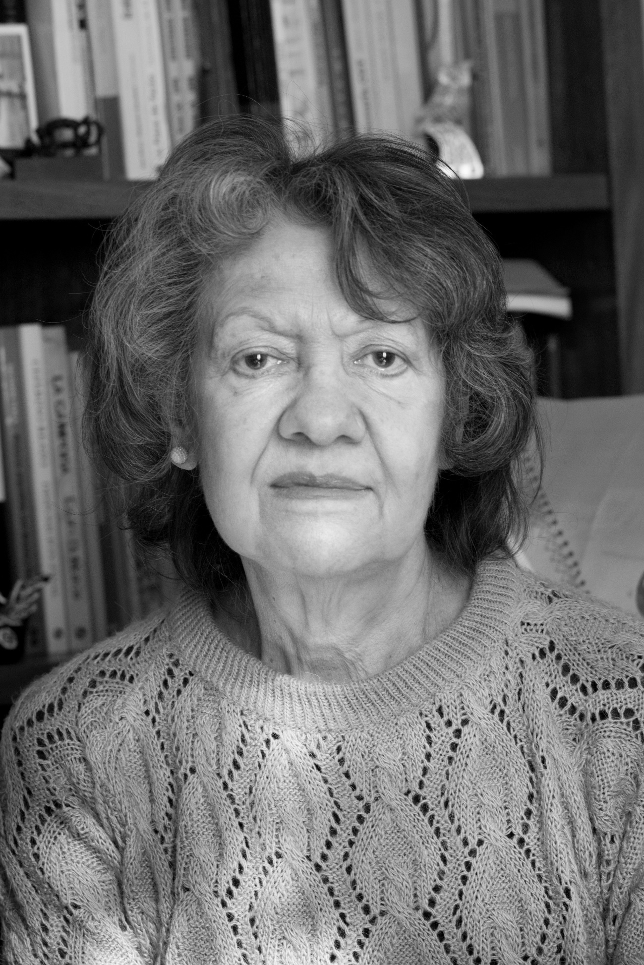 Imagen en blanco y negro de una mujer con suéter de color gris Descripción generada automáticamente