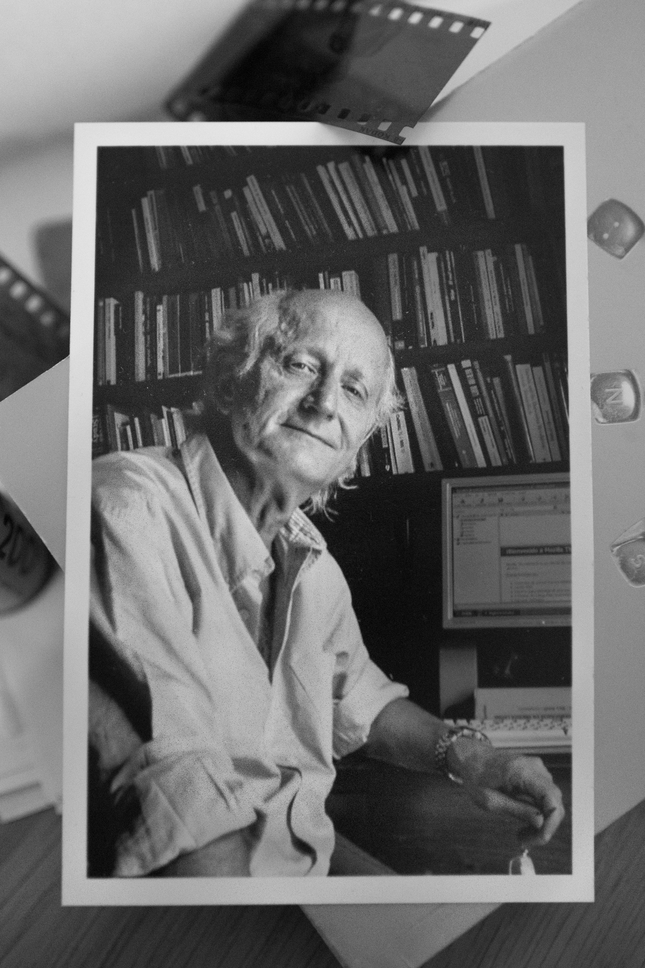 Foto en blanco y negro de una persona en un librero Descripción generada automáticamente con confianza media