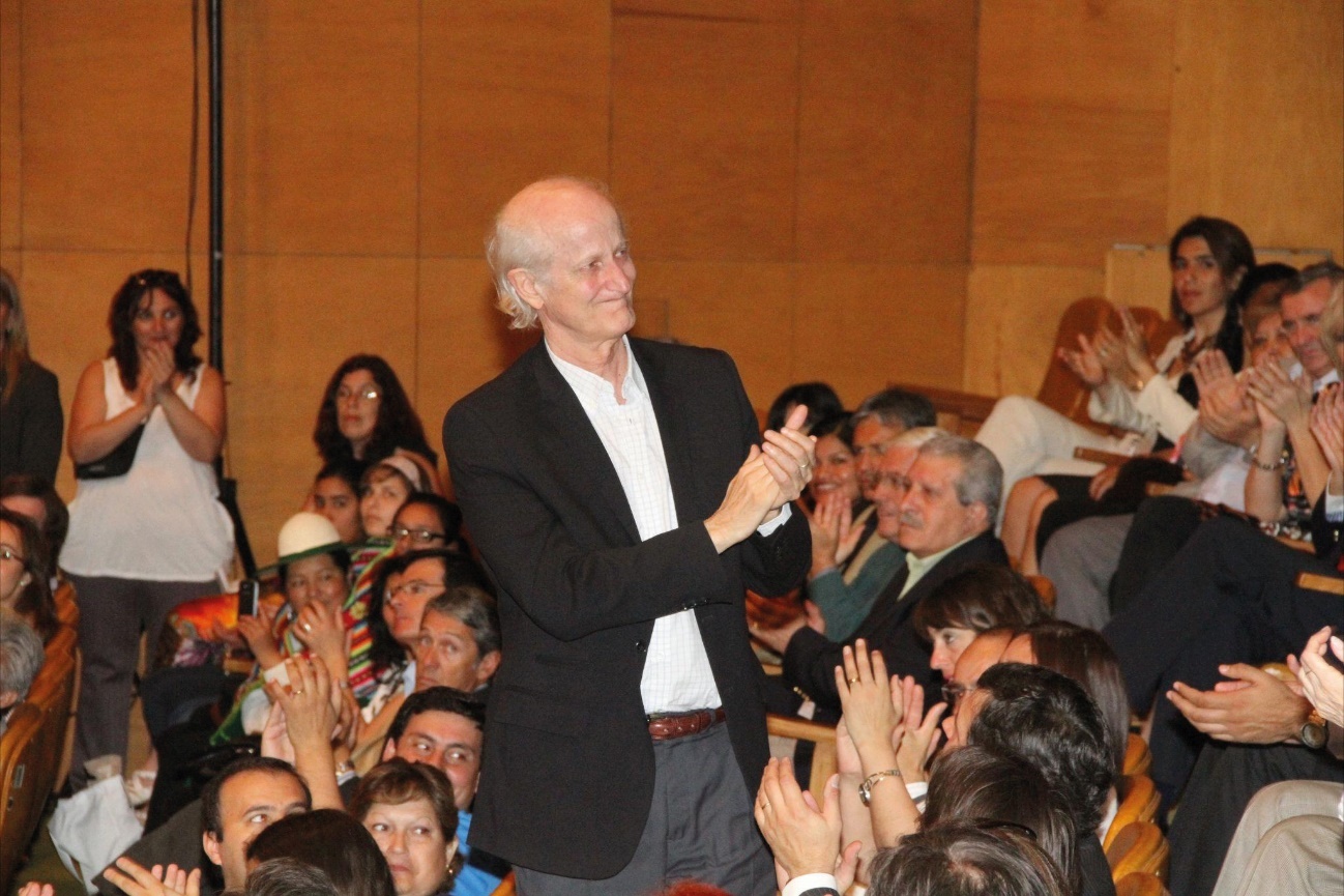 Un grupo de personas sentadas en una sala Descripción generada automáticamente