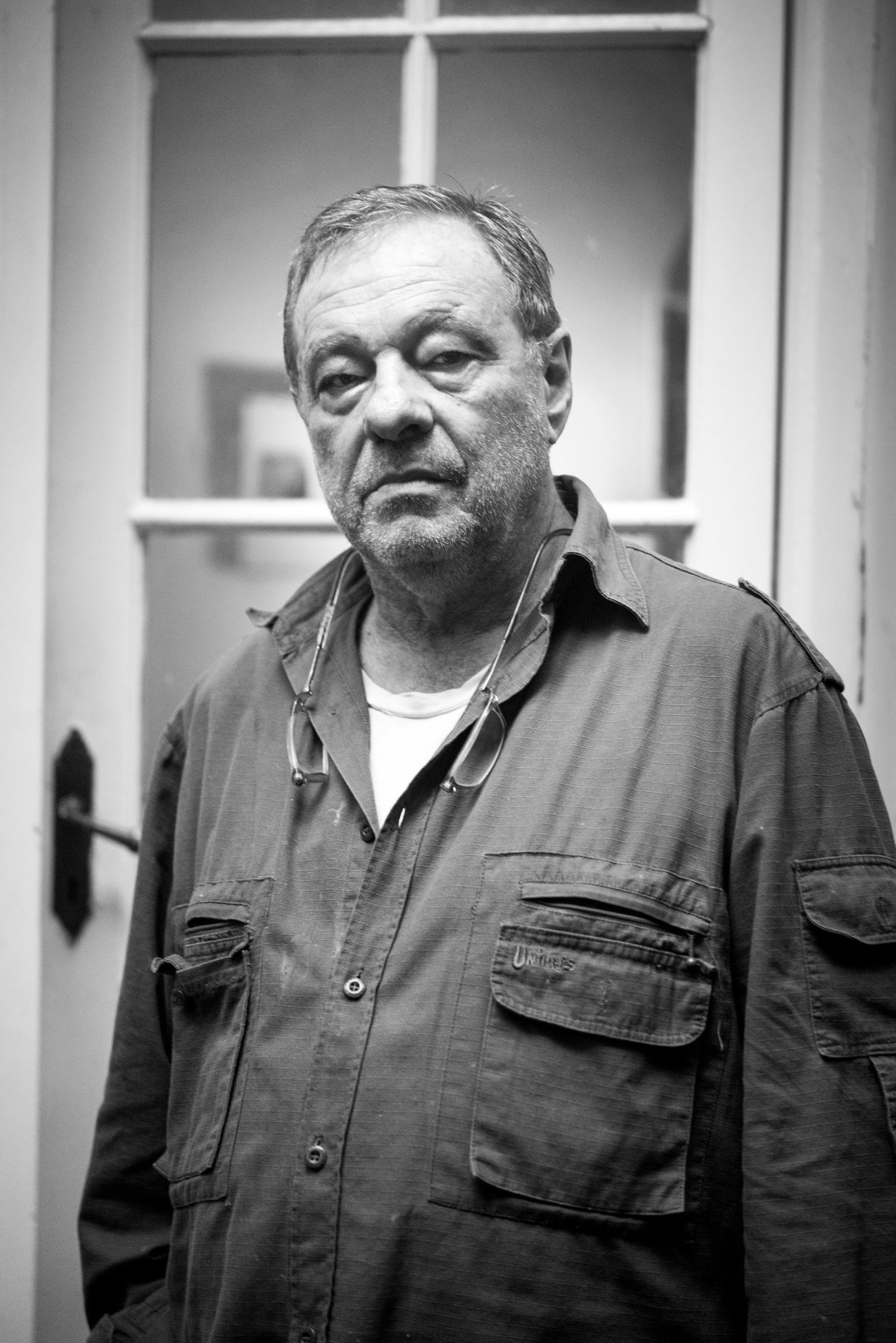 Imagen en blanco y negro de un hombre con la puerta abierta  Descripción generada automáticamente con confianza media