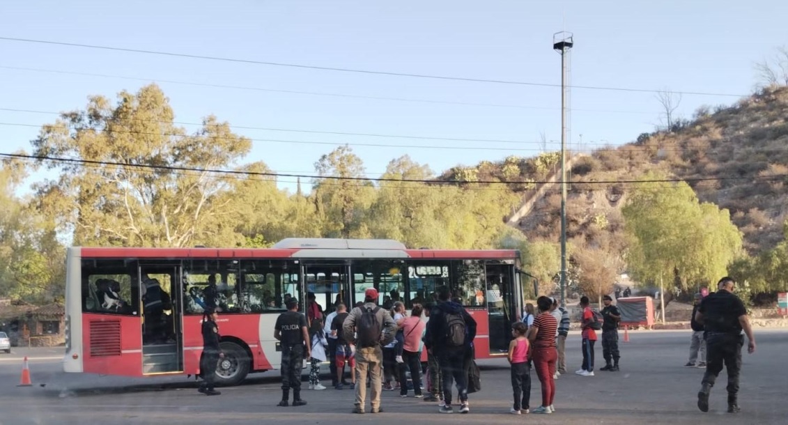 Un grupo de personas junto a un camión de bomberos en la calle  Descripción generada automáticamente